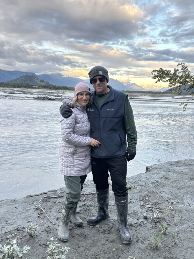 Philip Licht and his wife on the bank of the Matanuska River at sunset